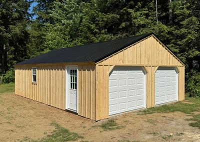 Wood Amish Built Garage with two white garage doors, a white side door, and a black roof