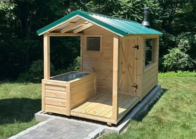 Amish Sauna with a green roof and porch with cold plunge tub